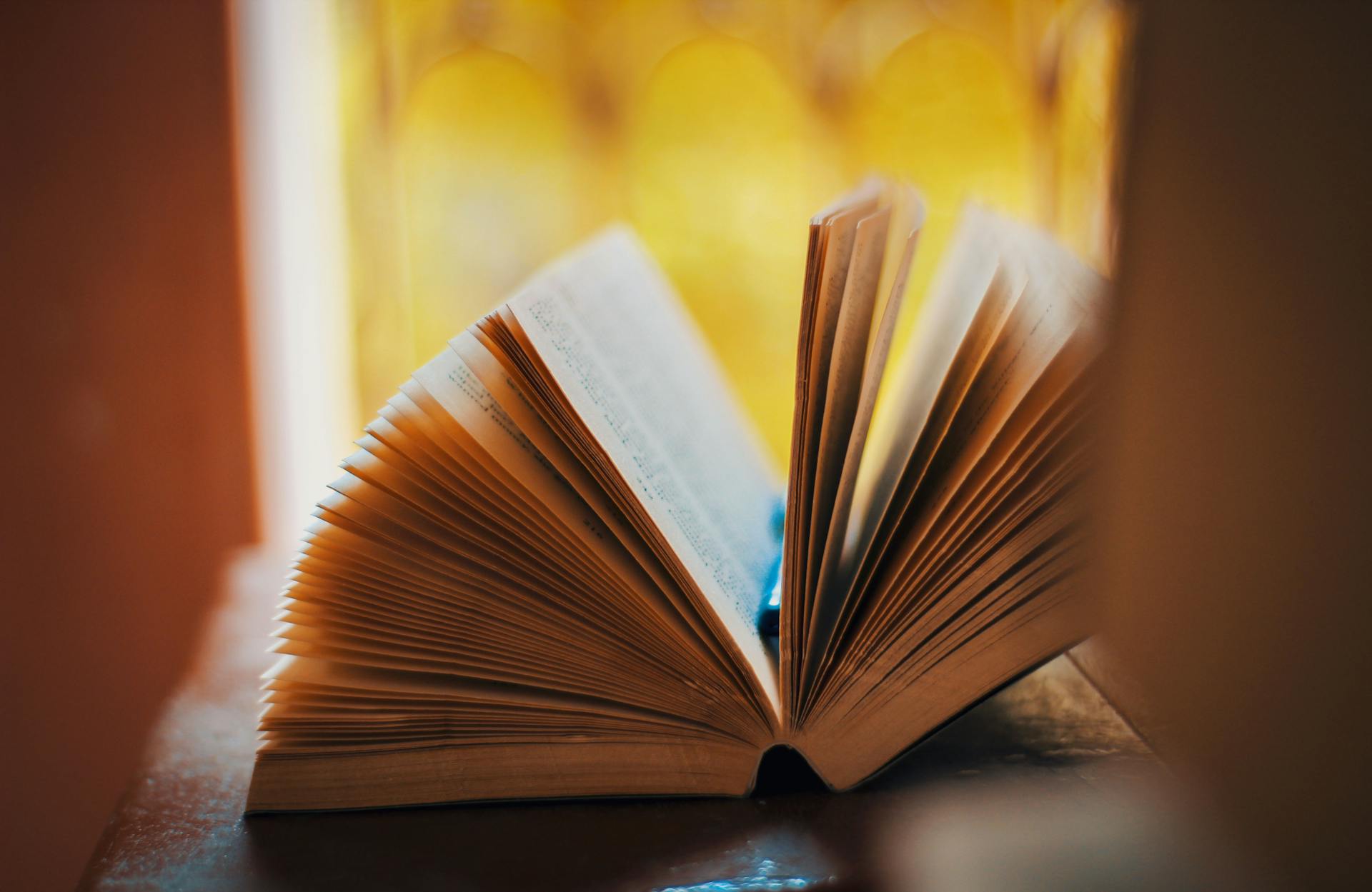 Open book pages softly lit on a wooden table