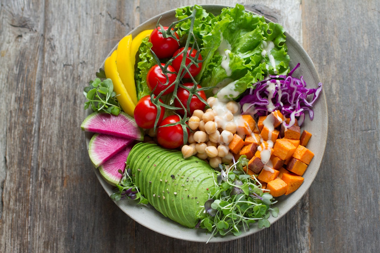 Overhead view of a colorful Buddha bowl with chickpeas, avocado, and vegetables