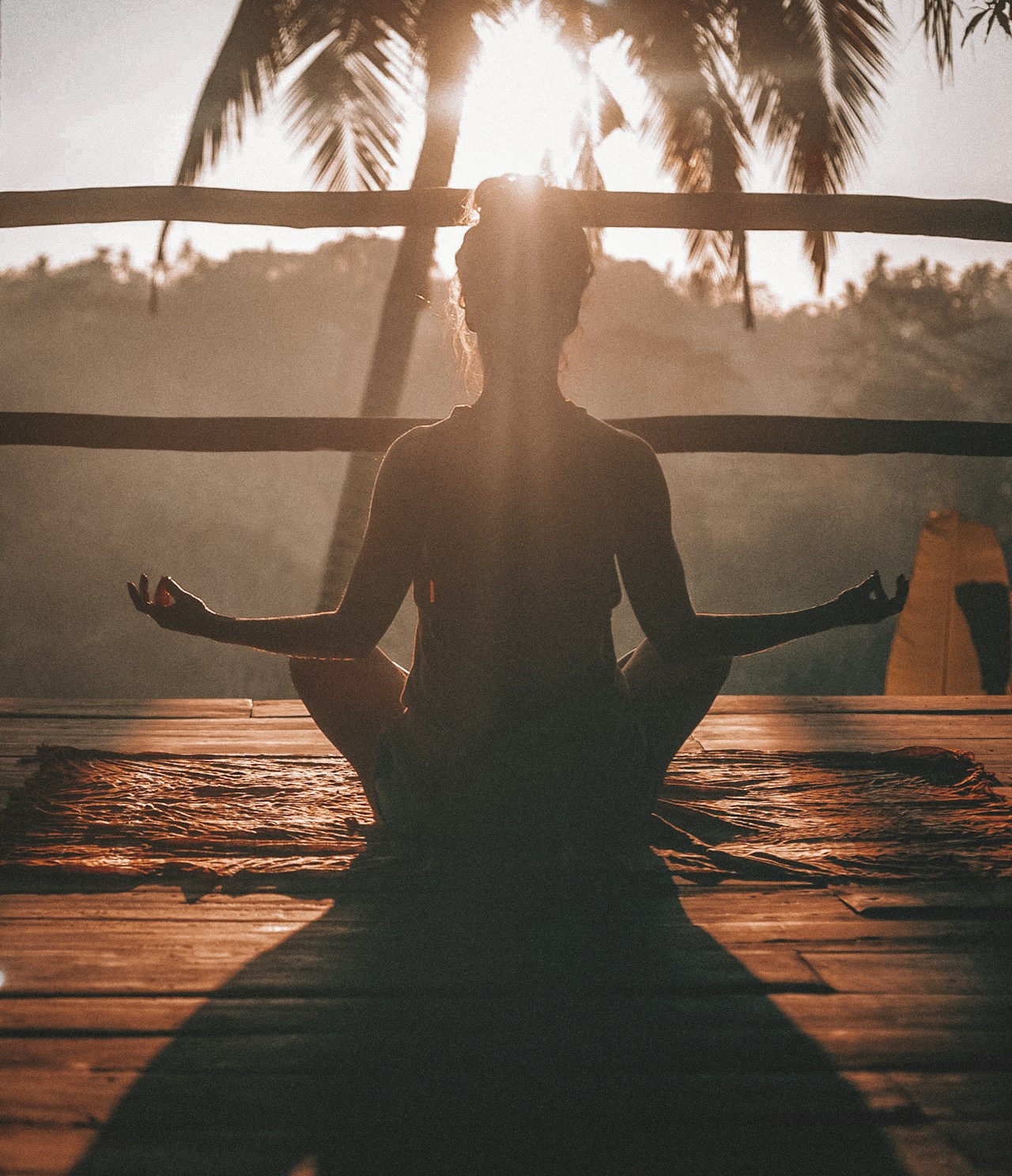 Person in a peaceful yoga pose on a mat in a bright studio